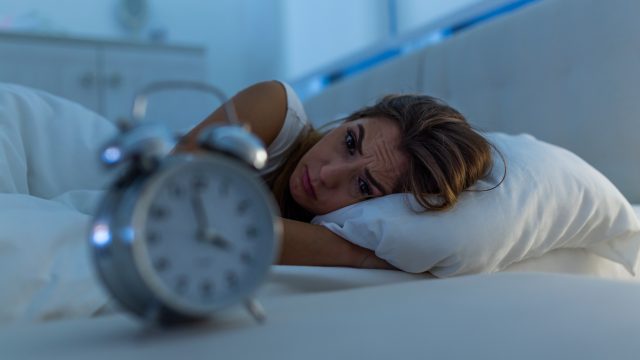 Woman with insomnia lying in bed