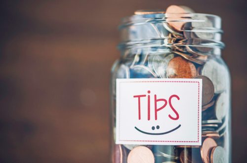 Tip jar with American currency on brown background