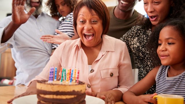 Multi-Generation Family Celebrating Grandmothers Birthday At Home With Cake And Candles