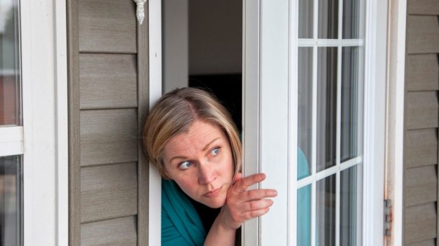 Woman Peering Out Her Window