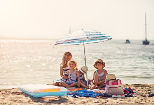Mother wit hkids having fun on the beach. Sunny summer day. Mallorca, Spain.
