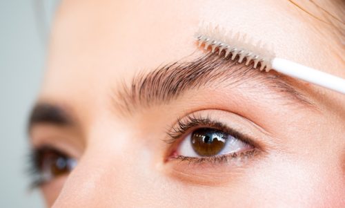 Closeup of woman using spoolie eyebrow brush