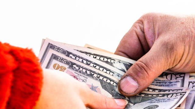 Hand giving money isolated, hard worked hand taking dollars money. Currency transfer on white background.