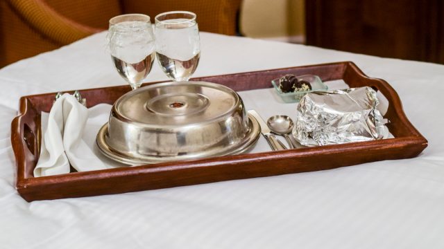Room service tray on bed in a hotel room.