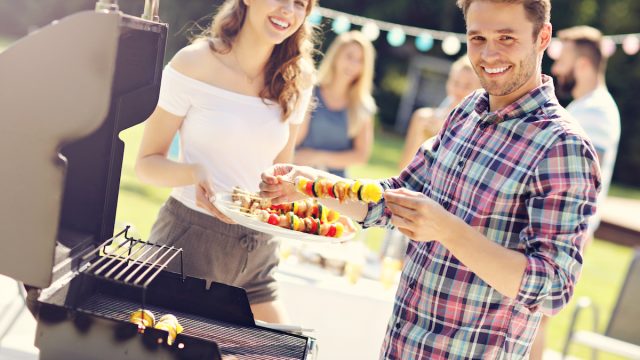 Friends having barbecue party in backyard