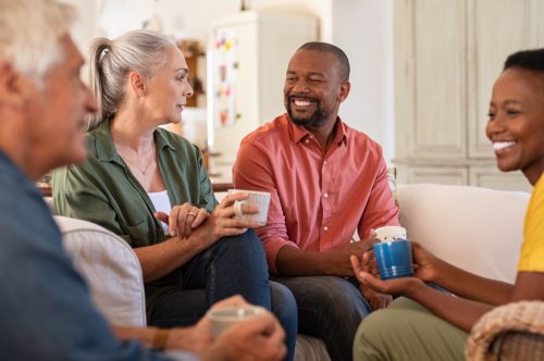 two men and two women drinking coffee and having a friendly conversation together
