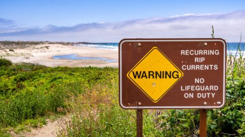 Warning sign about recurring rip currents and no lifeguard on duty