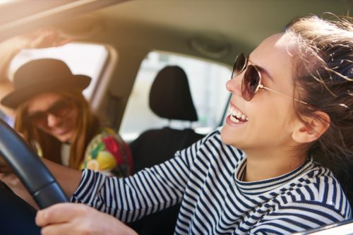 friends laughing in the car after one gives a funny response to "how are you"