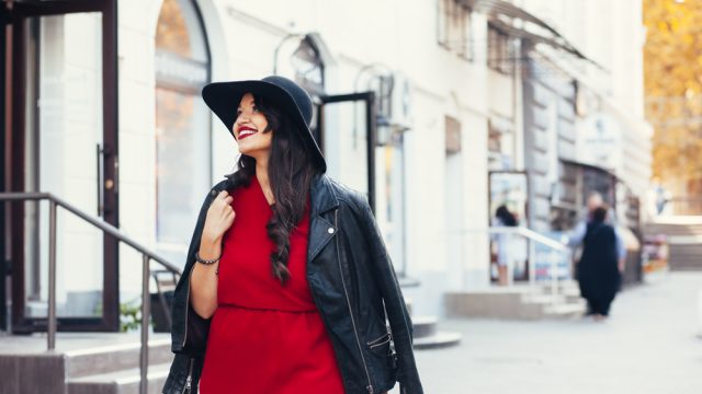Stylish woman in the city wearing red dress and black hat