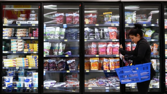 A shopper walking through the frozen food aisle at a Walmart