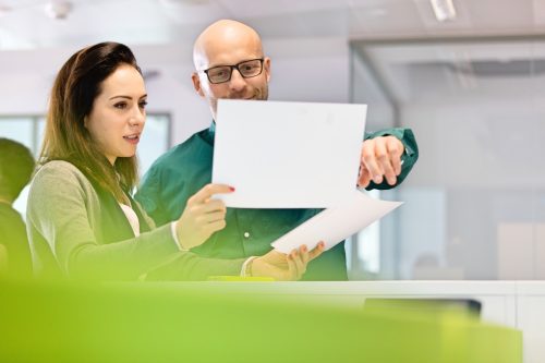 Man and Woman Looking Over Business Plans