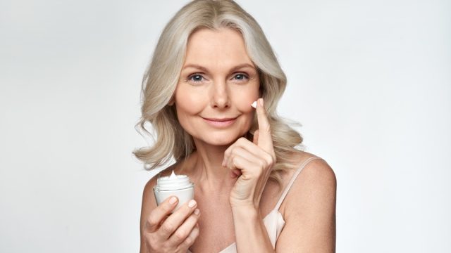 Smiling,50s,Middle,Aged,Mature,Woman,Putting,Tightening,Facial,Cream