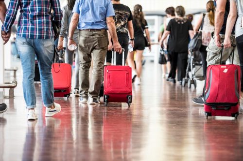 Travelers with suitcases walking through the airport