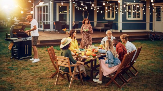 Family having a backyard BBQ at dusk
