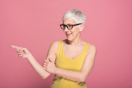 older woman wearing a sleeveless yellow top