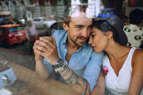 couple snuggling behind the window at a cafe