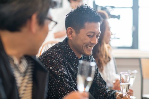Guests at a dinner party talking and drinking wine