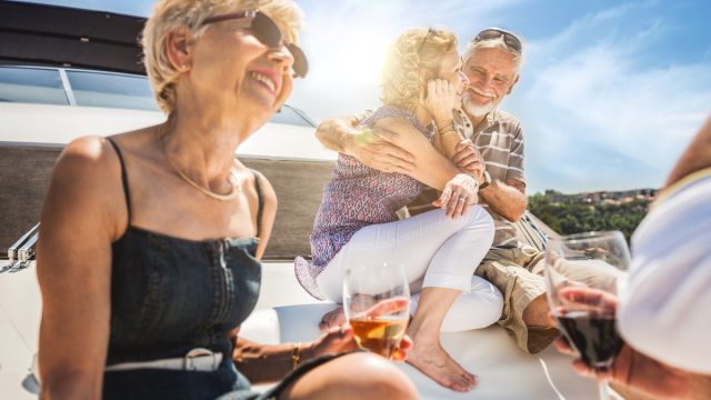 Senior friends toasting on a yacht
