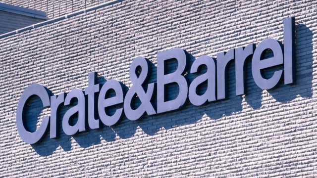A close up of a Crate & Barrel sign on a storefront