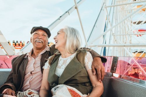 Senior man and woman enjoying a Ferris wheel by the Santa Monica pier