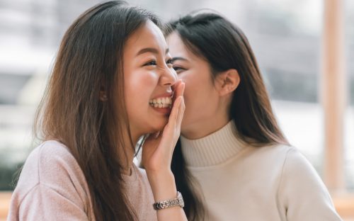 woman whispering funny paranoia questions to another woman
