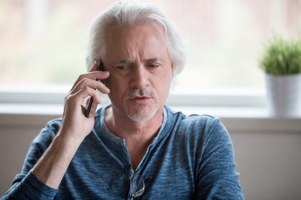 man confused while talking on the phone