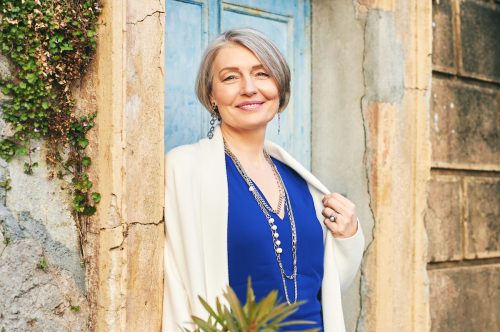 Fashion portrait of beautiful and elegant middle age woman posing outside