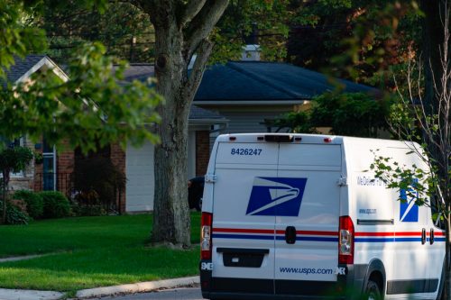 One of the newer Sprinter model USPS mail delivery trucks on a residential street in Rochester, Michigan.