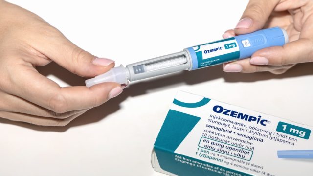 Close up of hands holding Ozempic drug