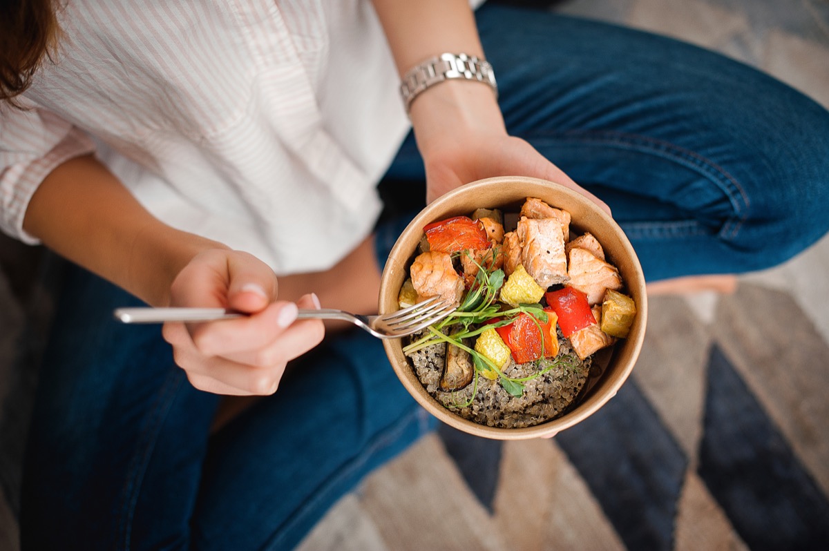 Top-down view of a Woman eating small bowl of healthy food