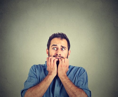Portrait anxious young man biting his nails fingers freaking out