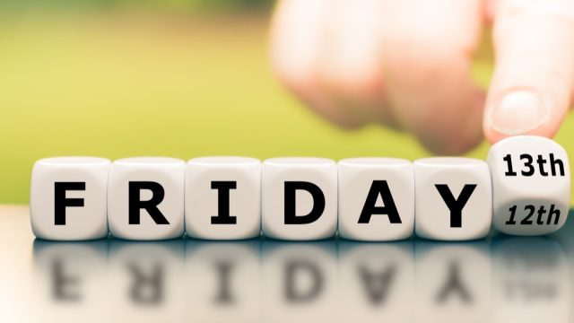 Hand turns a dice and changes the expression "friday 12th" to "friday 13th".