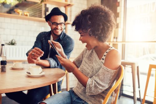 man and woman exchanging funny one liners at a cafe