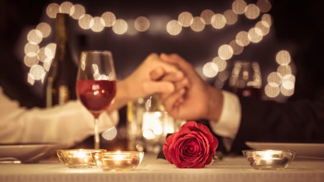 couple holding hands at a restaurant exchanging happy anniversary messages