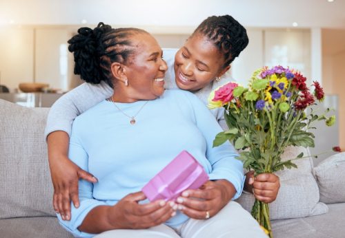 young girl delivering her mother presents, flowers, and happy birthday wishes