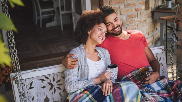cozy couple drinking coffee on porch