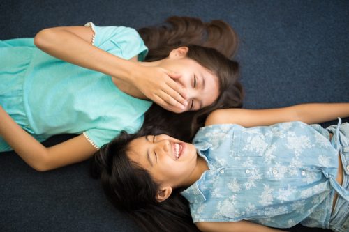 two little girls telling each other jokes for kids