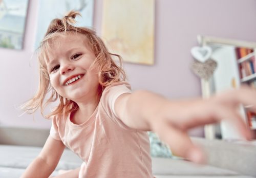 little girl laughing and playing at home