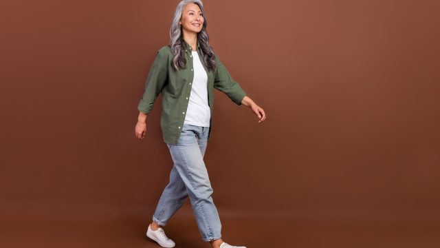 Mature woman long gray hair jeans and green shirt