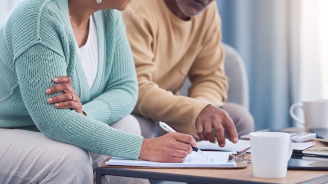 Senior couple, documents and sign contract for life insurance or home mortgage. Discussion, signature and retired elderly man and woman signing legal paperwork for will or loan application together.