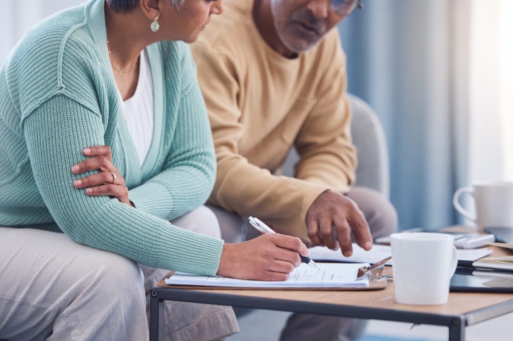 Senior couple sitting at table looking at documents