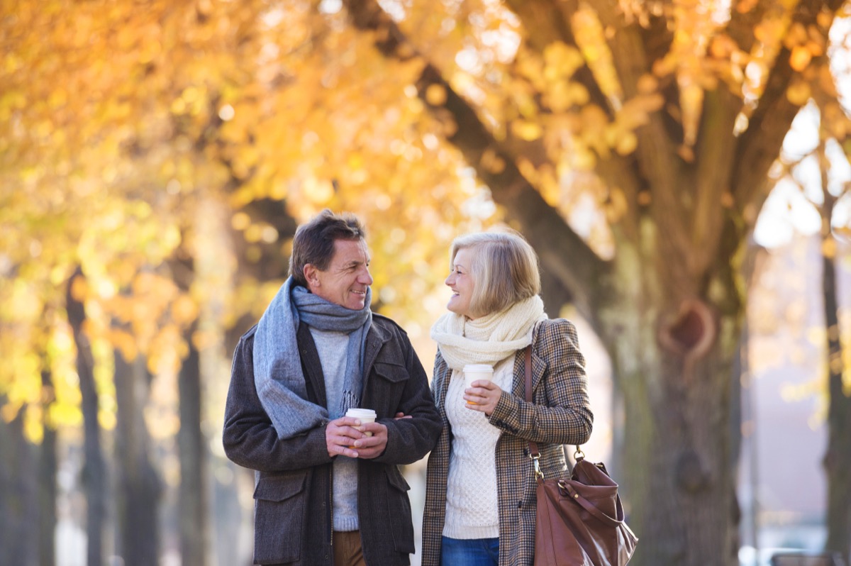 senior couple walking through town in autumn