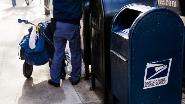 USPS worker emptying the mailbox on a MAnhattan street in New-York, USA on November 17, 2012.