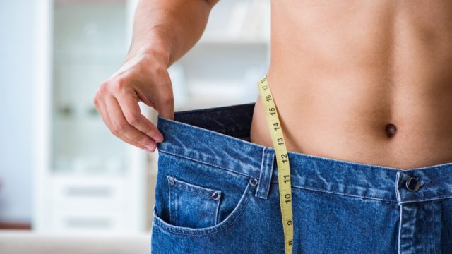 Man in oversized pants in weight loss concept