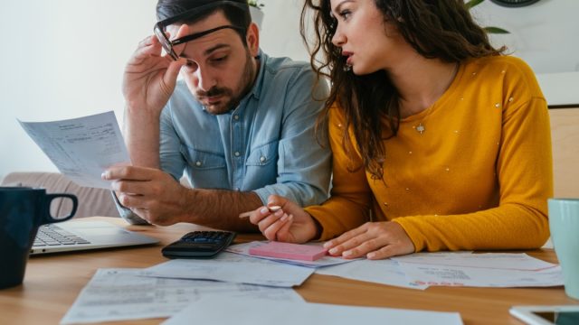 Serious Couple Paying Bills Together at Home.
