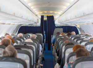 A view of a commercial airline cabin filled with seated passengers.