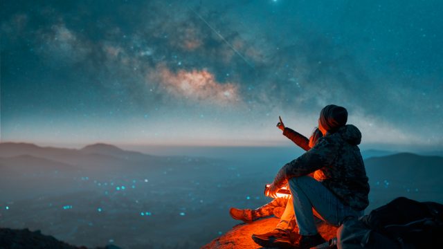 A couple looking at the Milky Way in the night sky