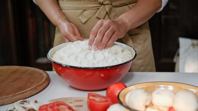 A close up of someone cooking using a vintage enamel bowl