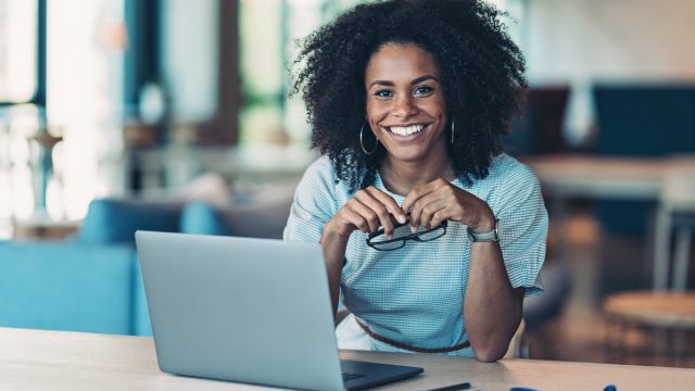 Portrait of a smiling businesswoman with a laptop in the office