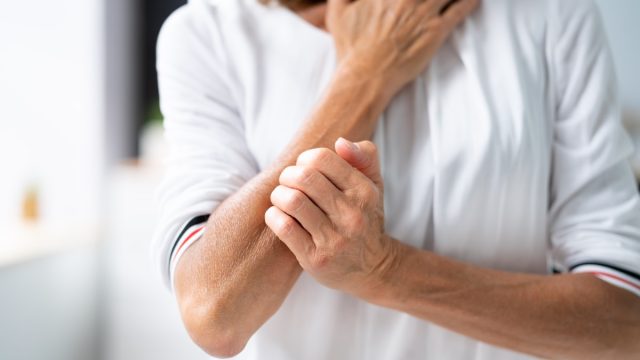 woman in pain holding arm